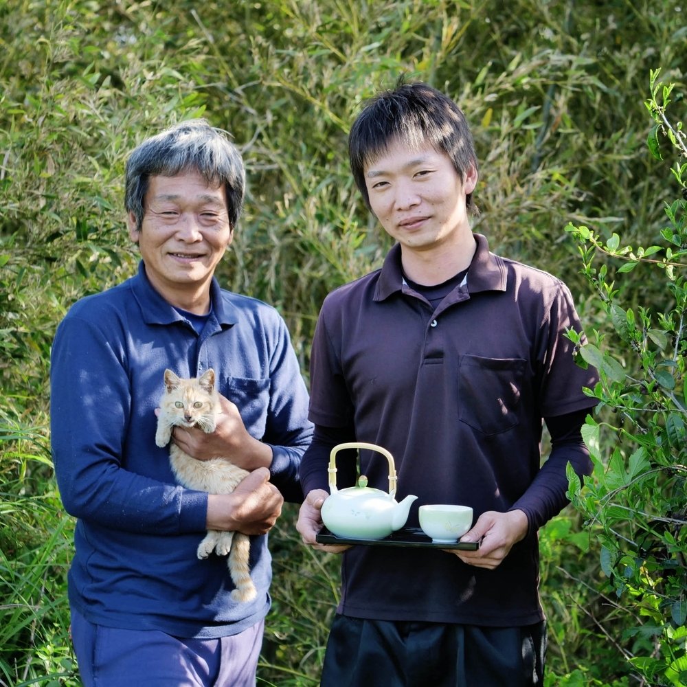 Familie Kadota mit einer Teekanne und einer Katze in den Armen.