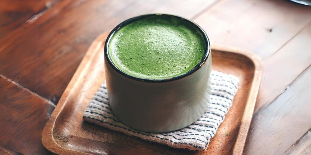 Ein aufgeschlagener Matcha in einer weißen Matchaschale.